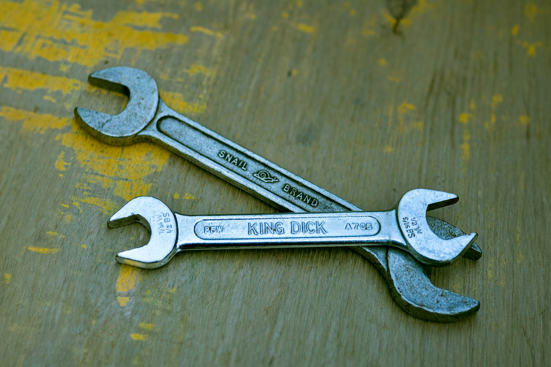 A wrench sitting on top of a wooden table